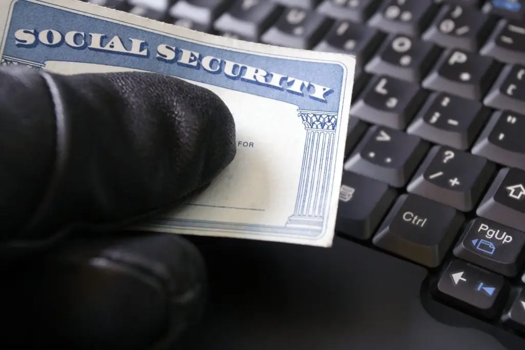 Closeup of a thief holding a Social Security card