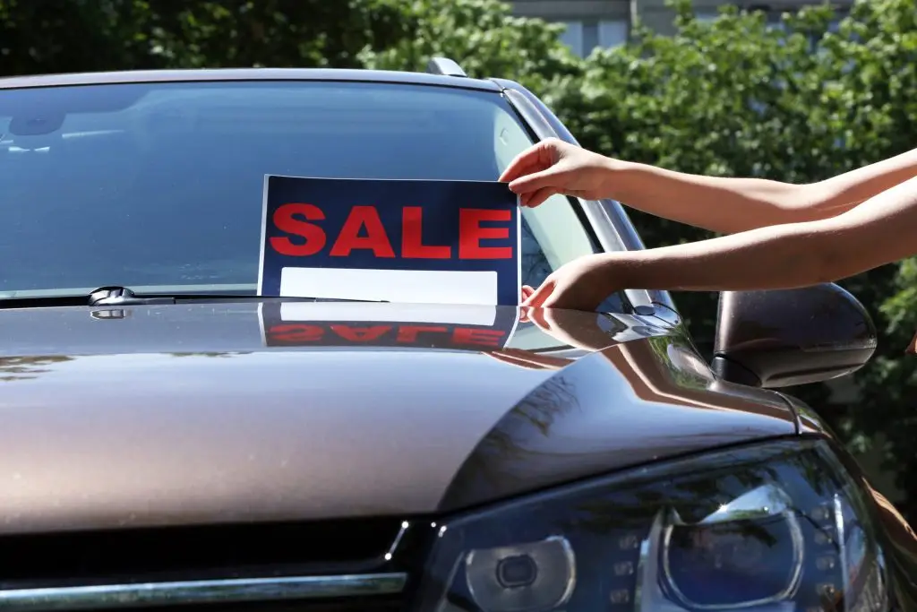 Putting a Sale sign on a car