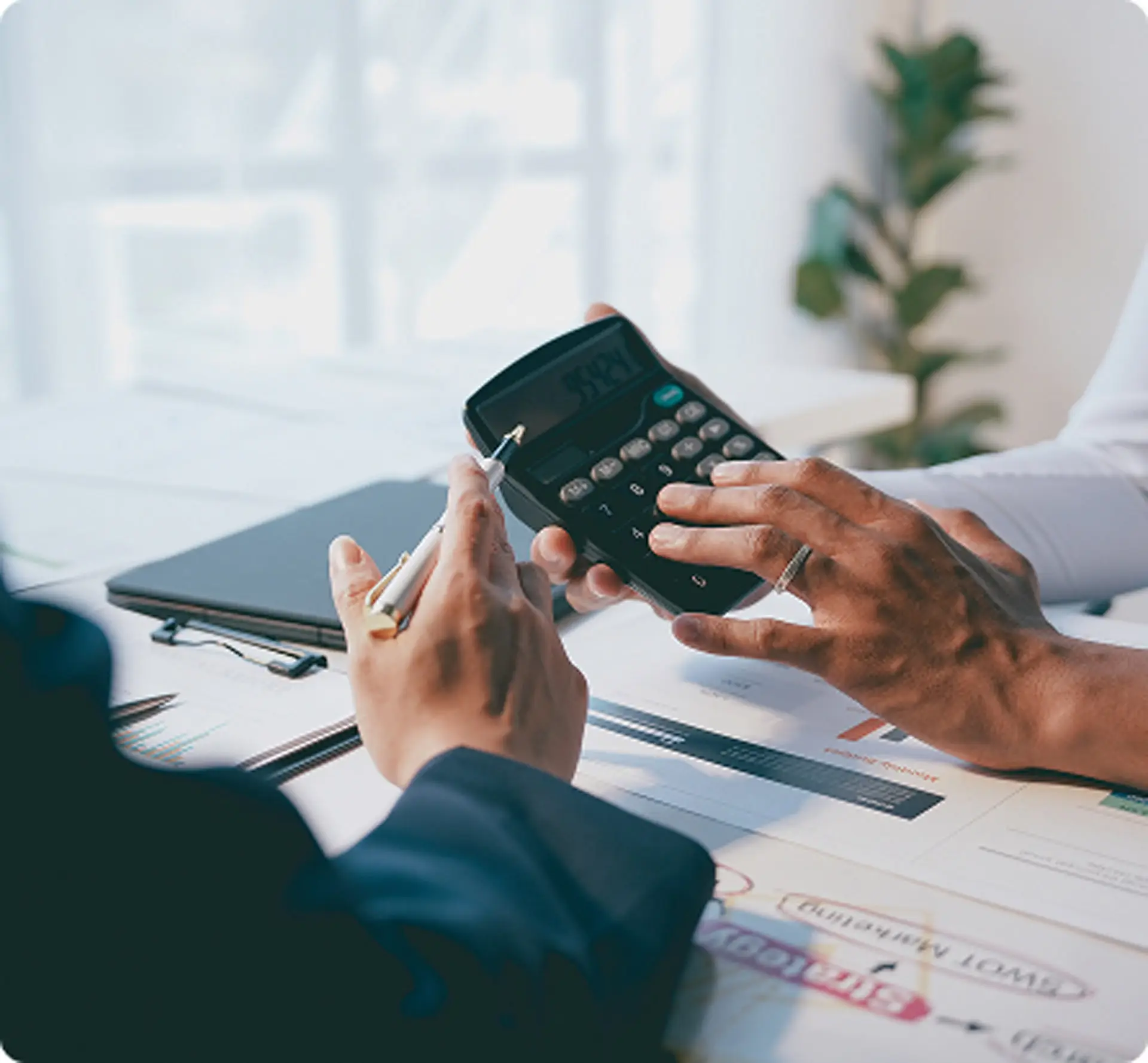 Closeup of hands using a calculator to help analyze financial reports