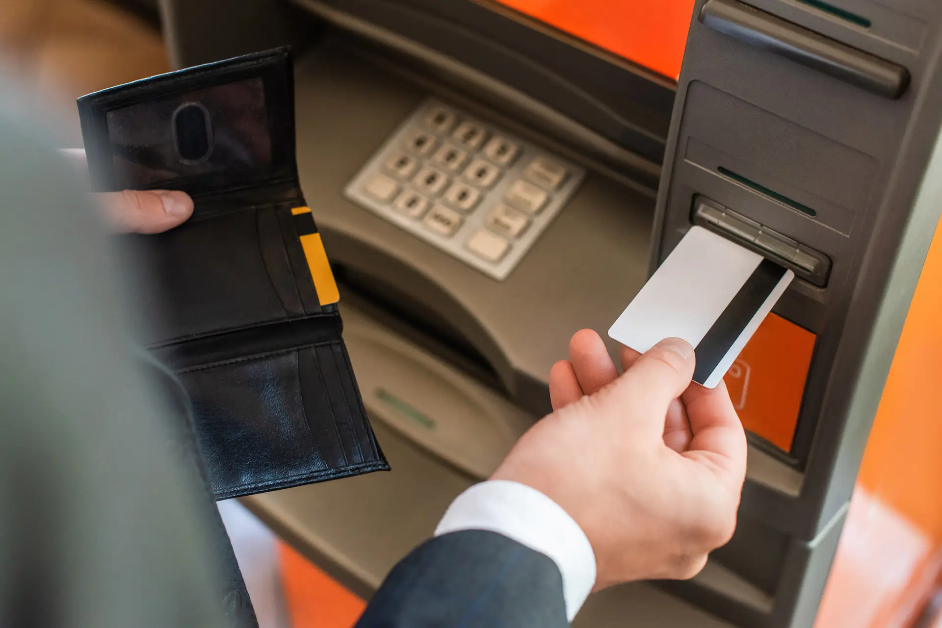 Closeup of someone putting a card into an ATM
