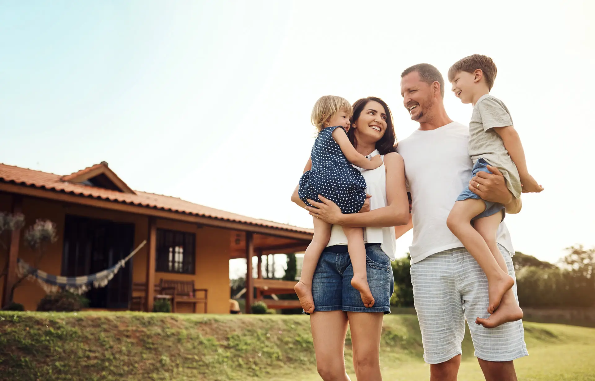 Parents holding their children outside of their house