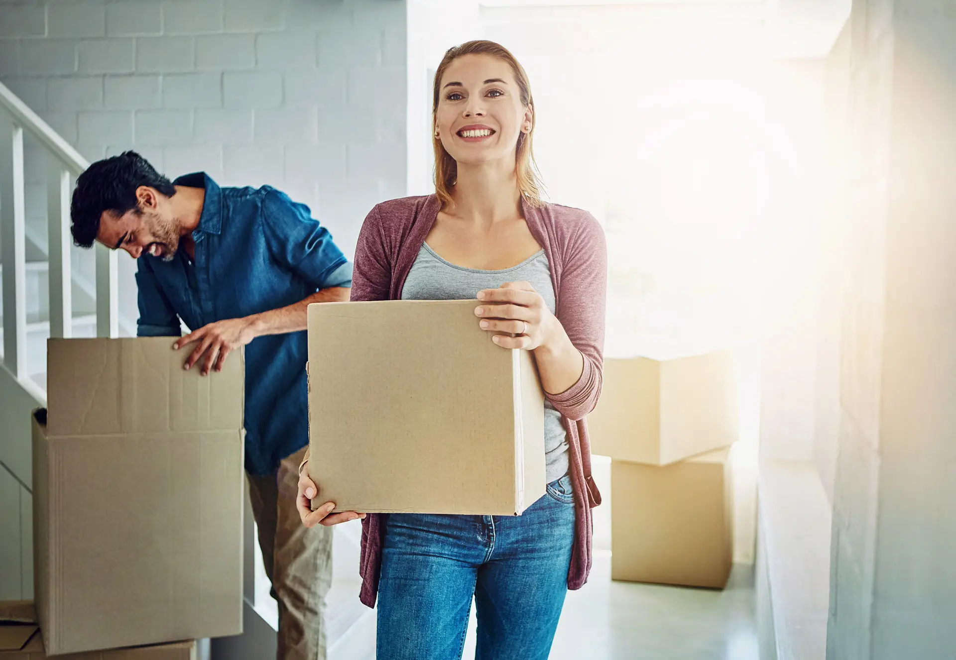 Couple moving boxes into their new home
