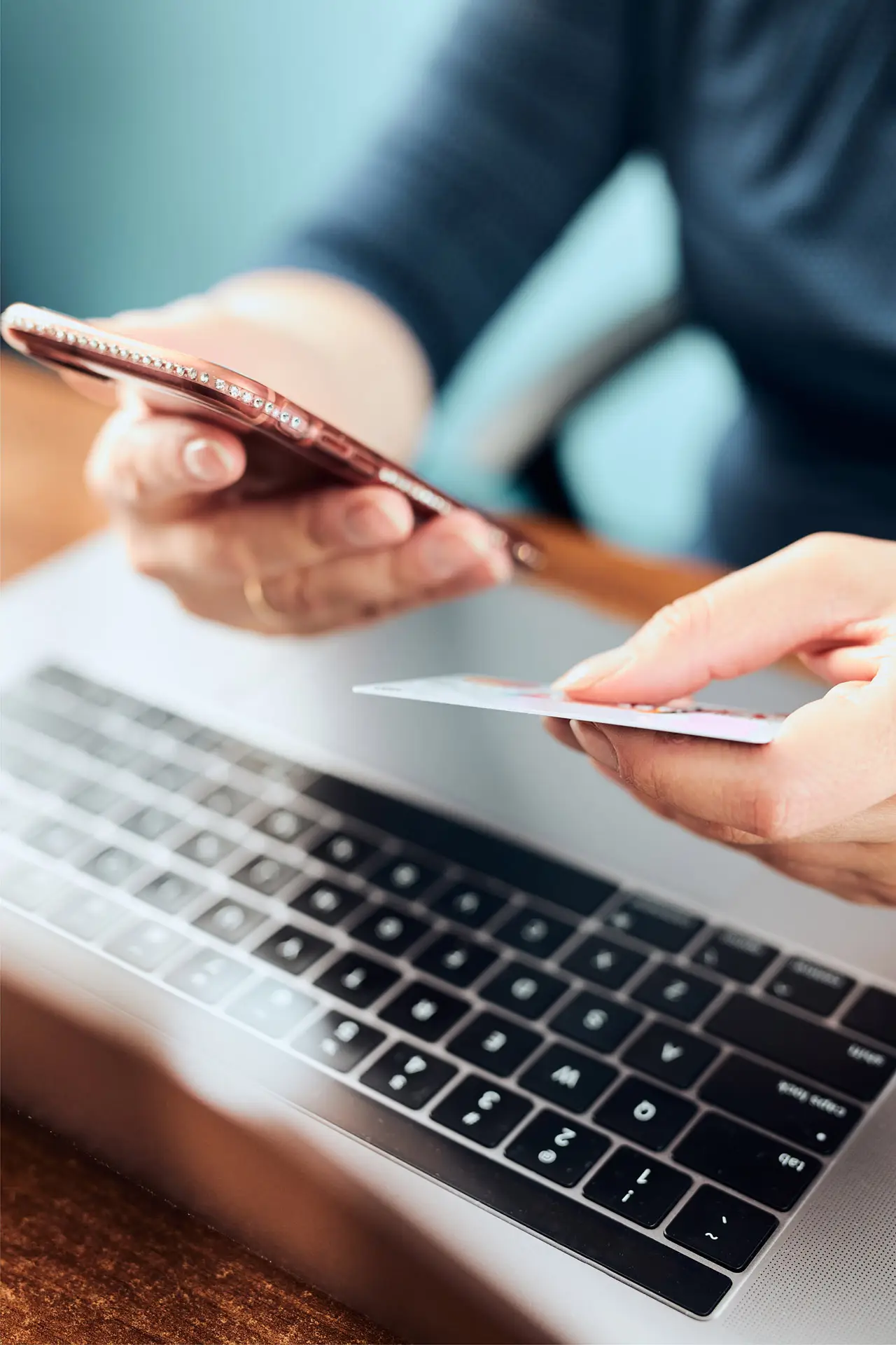 Closeup of one hand holding a cellphone while the other holds a credit card