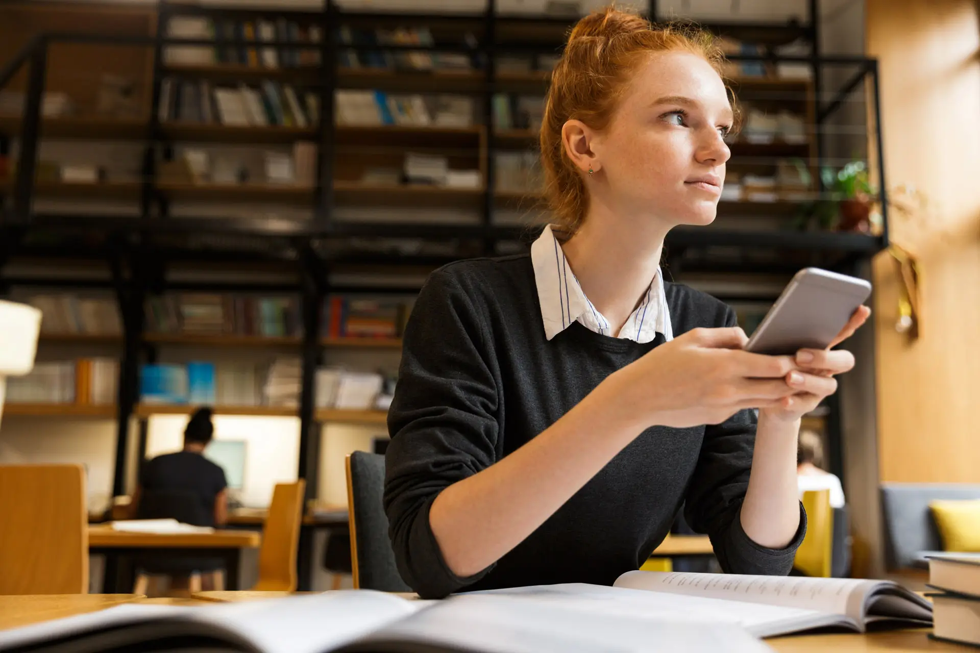 Woman at a desk holding her phone