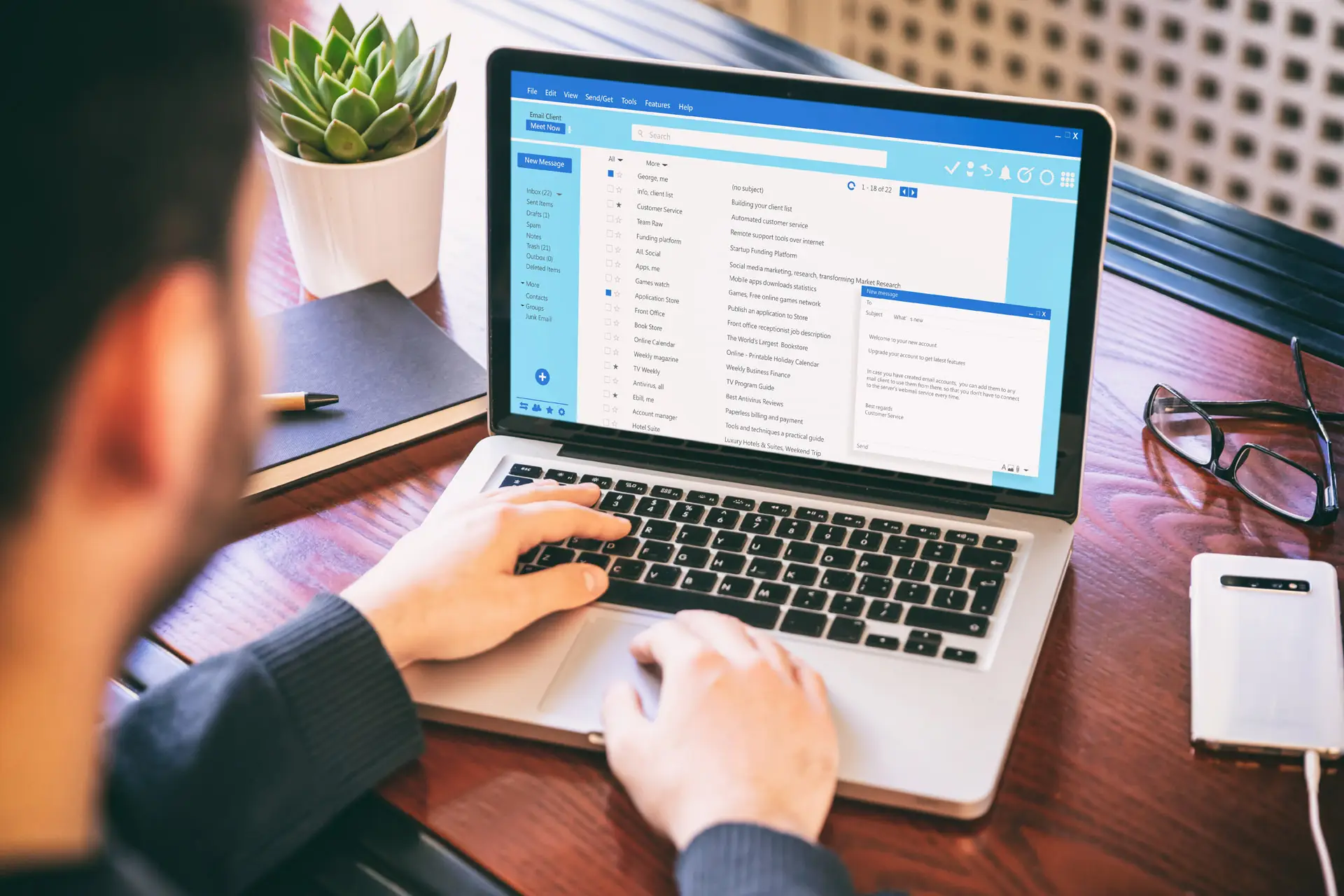 Closeup of a man using a laptop to check his email