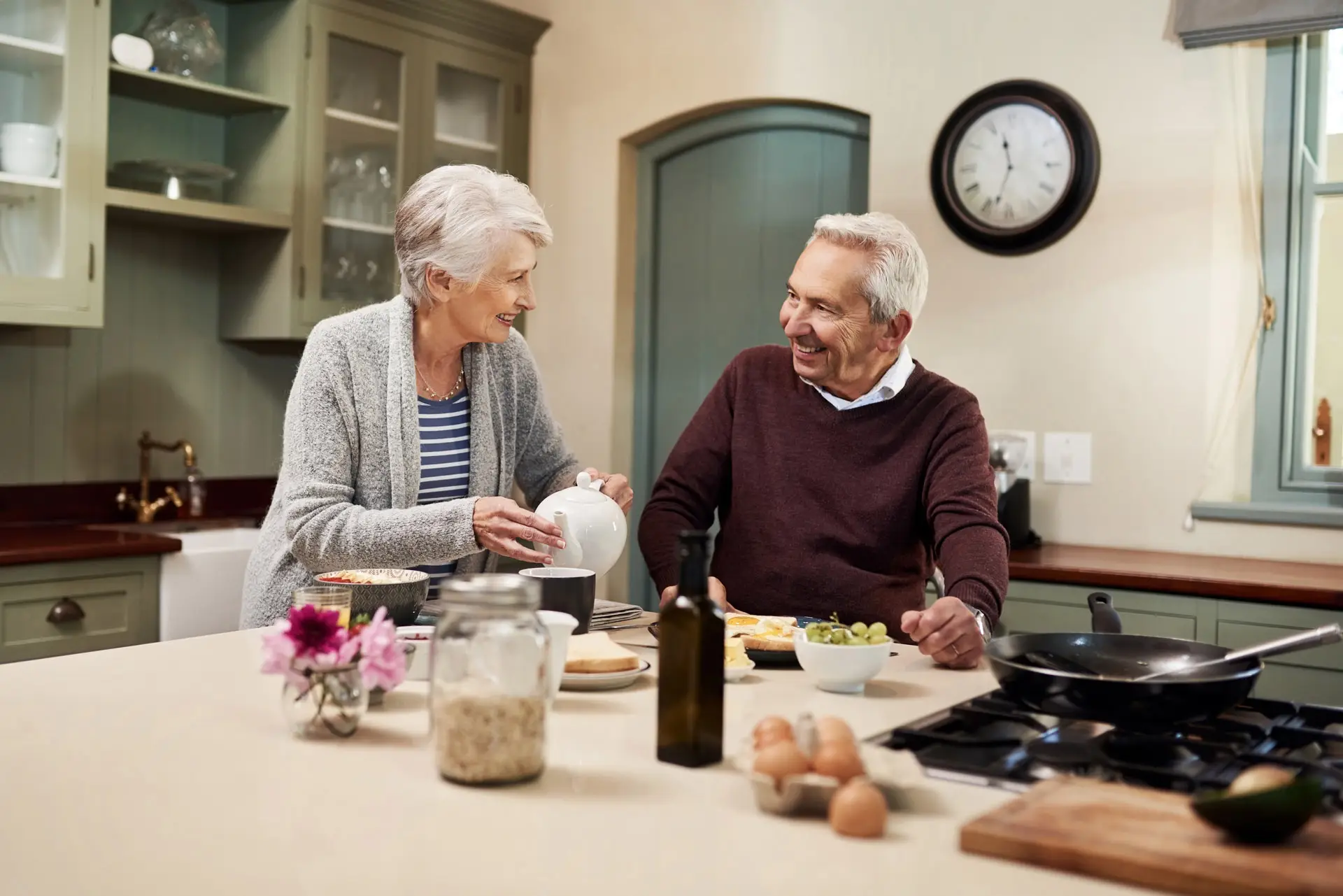 Senior couple smiling at each other while having breakfast