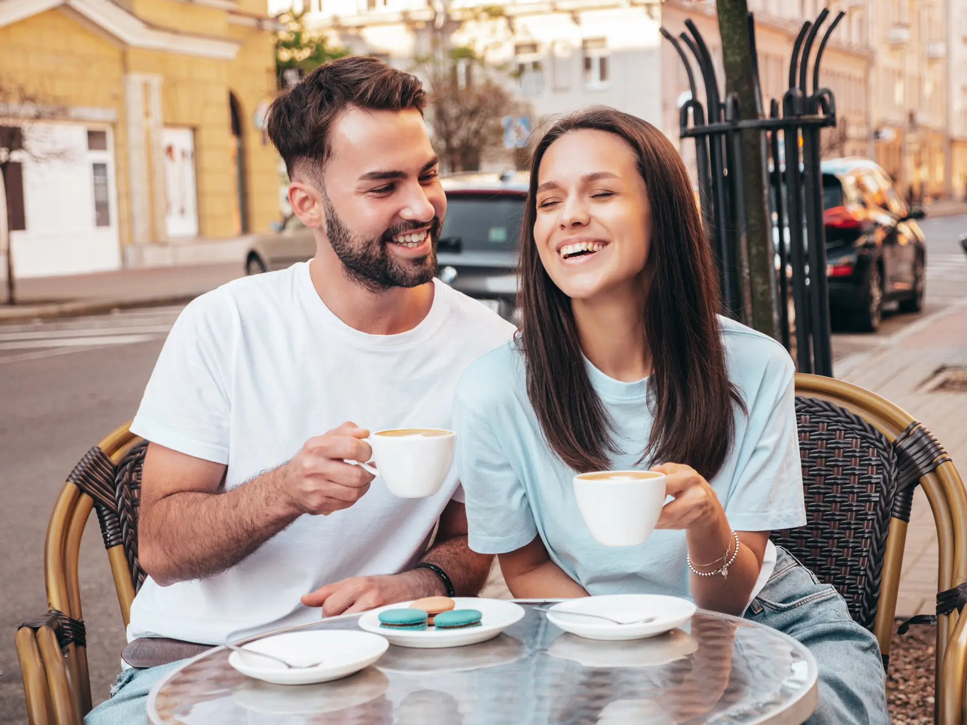 Smiling couple enjoying their coffee outdoors at a cafe