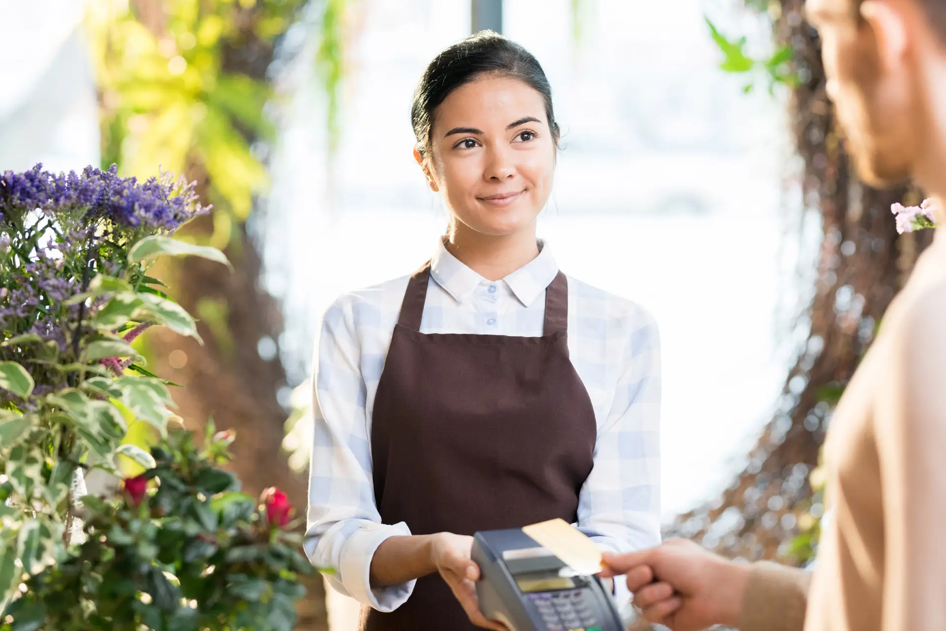 Flower shop employee accepting a payment from a customer