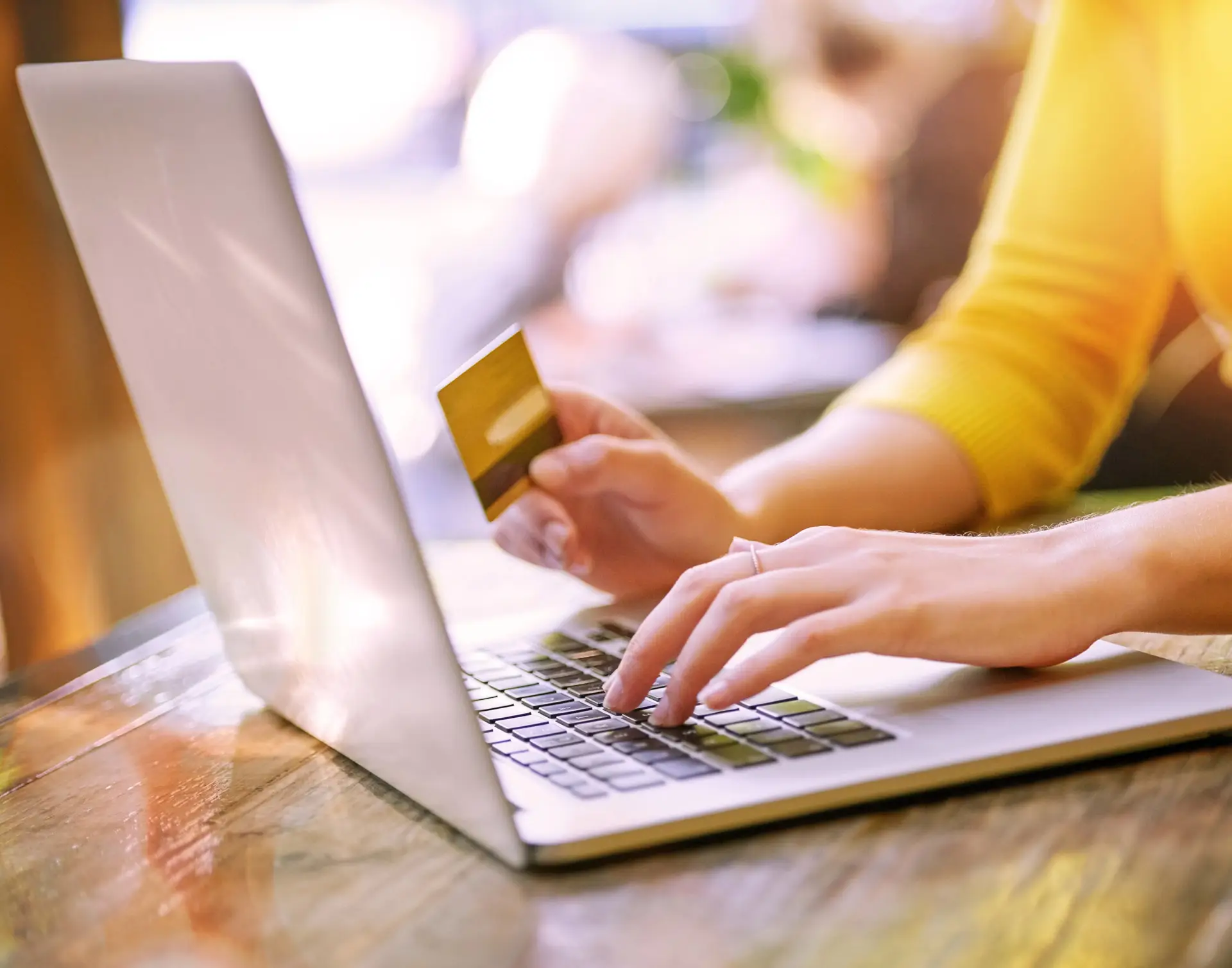 Woman using her laptop with a credit card in hand